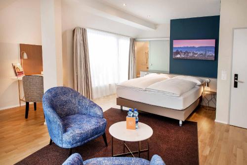 苏黎世雷克斯速乐酒店的配有一张床和一把椅子的酒店客房