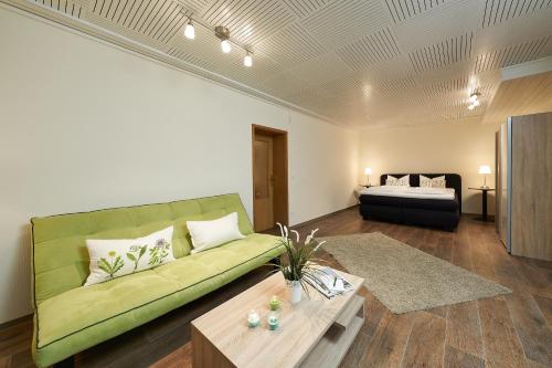Kirchberg卡伦贝格兰德酒店的客厅配有绿色沙发和桌子
