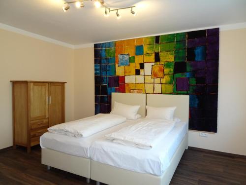 法兰肯塔尔费灵维斯图本餐厅&酒店的一间卧室配有一张壁画床