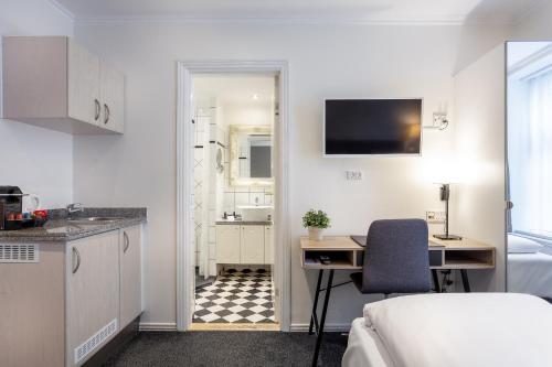 哥本哈根蒂凡尼酒店的客房设有厨房、书桌和床。
