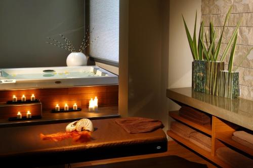 普拉卡利特索罗Cavo Olympo Luxury Hotel & Spa - Adult Only的带浴缸和蜡烛桌的浴室