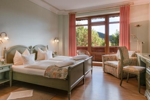 阿德瑙施奈霍夫兰德豪斯酒店的一间卧室设有一张床和一个大窗户
