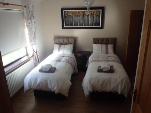 CoalislandTorrent Cottage的一间卧室配有两张床、帽子和毛巾