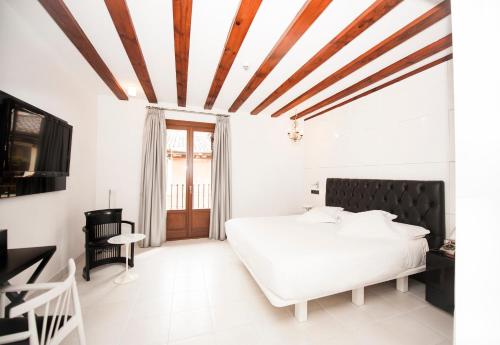 马德里金狮精品酒店的卧室设有白色的床和木制天花板。