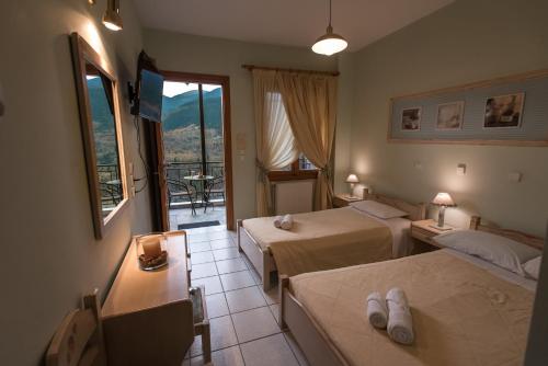 梅加克瑞奥Το Ηλιοβασίλεμα的酒店客房设有两张床和一个阳台。