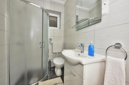 马卡尔斯卡Apartments Song of Joys的白色的浴室设有水槽和淋浴。