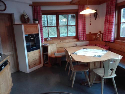 东蒂罗尔地区马特赖Obertimmeltaler的厨房配有木桌和桌椅