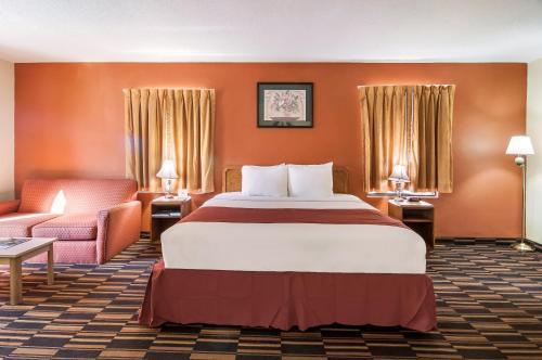 欧文顿Red Carpet Inn Newark - Irvington NJ的酒店客房带一张大床和一把椅子