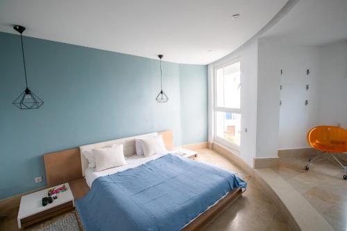 迦玛特The View Gammarth的一间卧室设有一张床和蓝色的墙壁