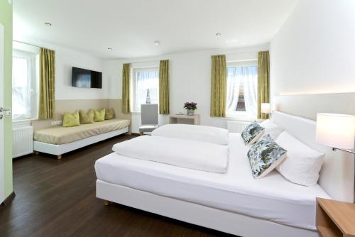 林登贝格拜耶里斯彻酒店的一间白色的大房间,配有两张床和一张沙发