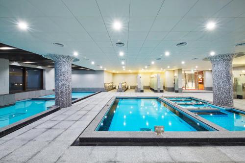 平昌Pyeongchang Ramada Hotel & Suite by Wyndham的大楼里一个蓝色的大泳池