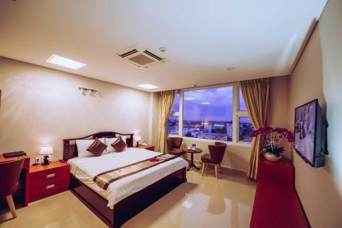 Tây NinhVictory Hotel Tây Ninh的酒店客房设有一张床和一个大窗户