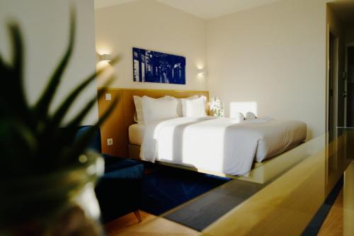 波瓦-迪瓦尔津ó Poboa Guesthouse的卧室配有一张白色大床