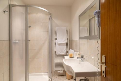 科拉尔博喜博格乐酒店的白色的浴室设有水槽和淋浴。
