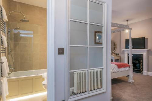 亨斯坦顿赫奥叉姆玛诺酒店的带淋浴和浴缸的浴室以及一间卧室