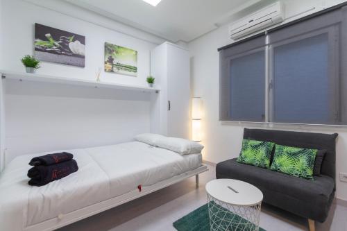马德里Fuencarral Studio的一间卧室配有一张床、一张沙发和一个窗口