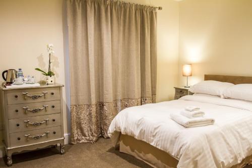 埃克塞特埃克斯特菲尔奥克豪斯旅馆的一间卧室配有床和一个带毛巾的梳妆台。