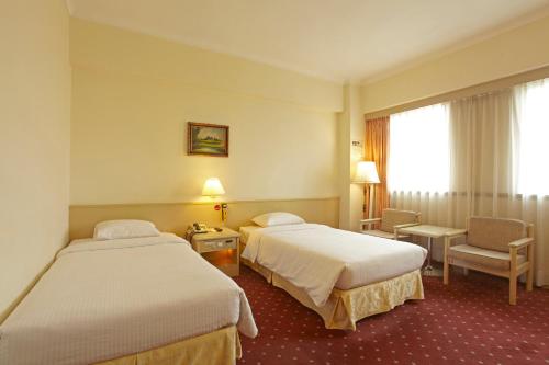 台北国王大饭店的酒店客房,配有两张床和椅子