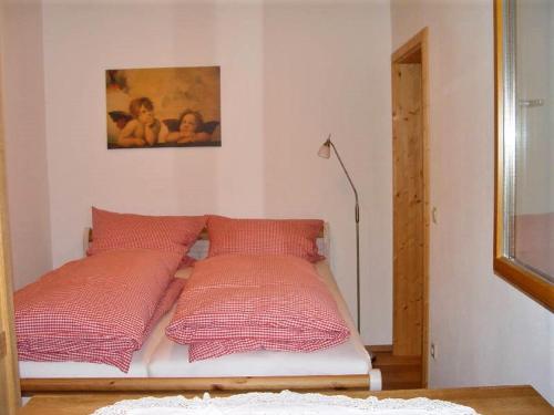 苏尔茨堡Haus Weichart的一张带四个红色枕头的床