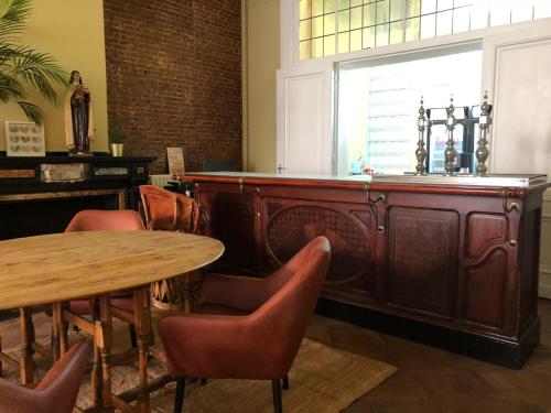安特卫普安特卫普布莫朗旅舍的餐厅设有木制酒吧,配有椅子和桌子