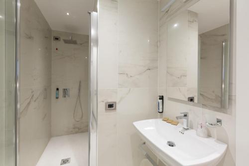 罗马弗洛里斯酒店的白色的浴室设有水槽和淋浴。