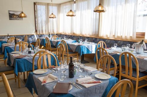 费德拉帕加内拉蒙大拿酒店的一间配备有蓝色桌椅的用餐室