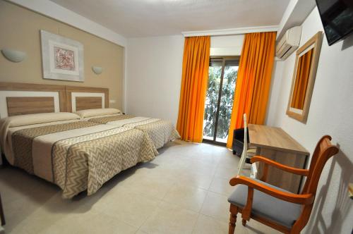阿尔姆尼卡戈雅酒店的一间卧室设有两张床、一张桌子和一个窗口。