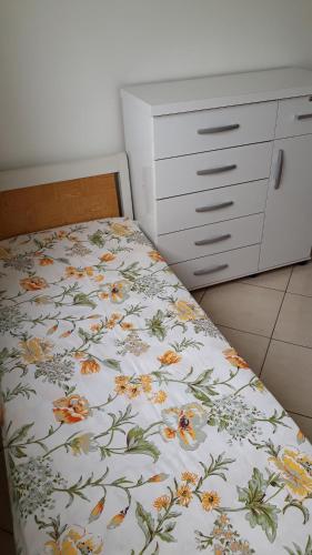坎普斯戈伊塔卡济斯Apartamento Orquídea的一间卧室配有一张带花卉床罩的床