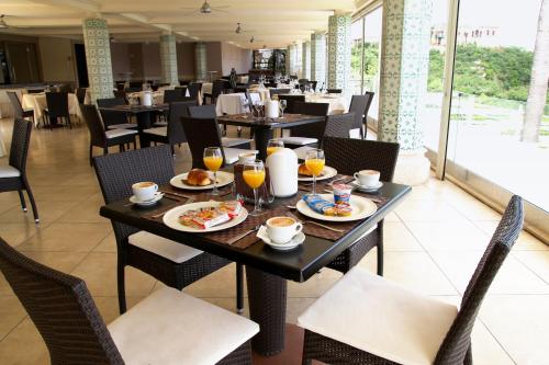 巴科利伊尔甘比亚诺酒店的一间餐厅配有桌椅,提供食物