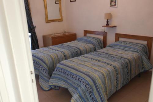 拉波拉诺泰尔梅Casetta delle Terme的客房内的两张床,上面有蓝色的床单