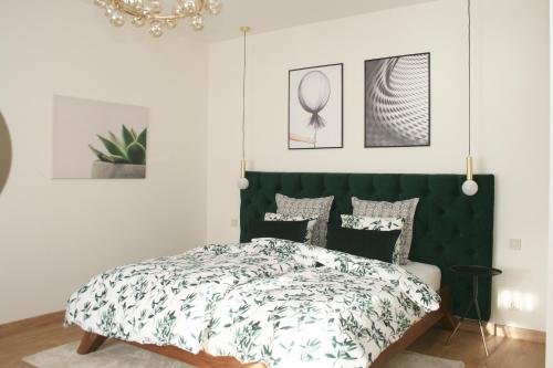 利耶帕亚Elegant apartment的一间卧室配有一张带绿色床头板的床