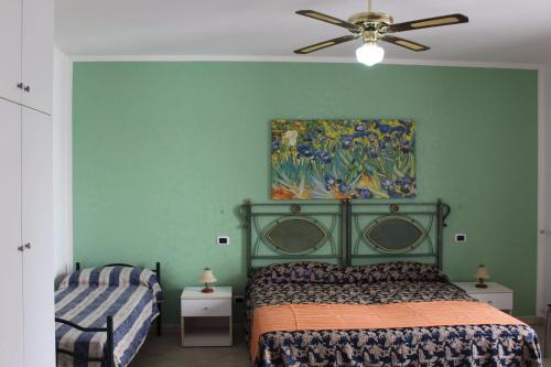 拉卡莱Casa Vacanza Alba 8-10 posti letto的卧室配有一张床,墙上挂有绘画作品