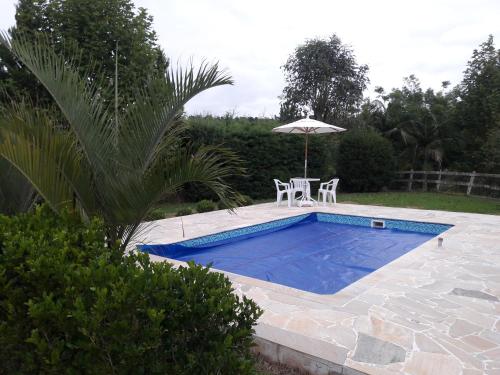 圣安东尼奥-杜皮尼亚尔Estância Liberdade的一个带桌子和遮阳伞的游泳池