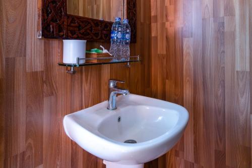 蓝梦岛威尔冲浪简易别墅酒店的一间带白色水槽和木墙的浴室