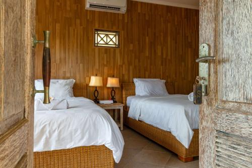 蓝梦岛威尔冲浪简易别墅酒店的一间卧室设有两张床和窗户。