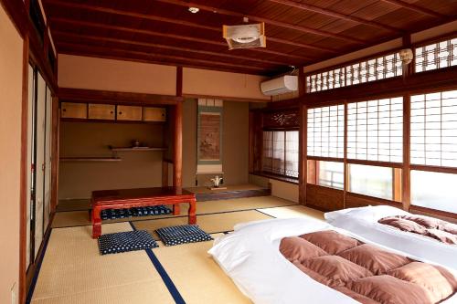 奈良Hotobil B&B 潤 An inn that enjoys breakfast的客房设有两张床、一张桌子和窗户。