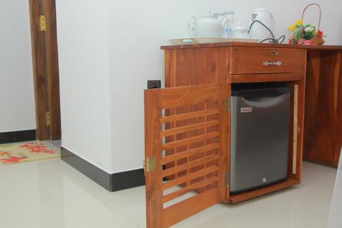 米瑞莎Maduranga n Guest的厨房配有带小冰箱的木制橱柜