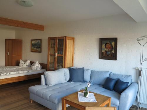 青斯特Ferienhaus Kaptein Meyer的客厅配有蓝色的沙发和床。
