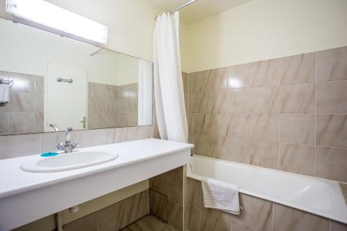 卡尔特汉理查迪酒店的一间带水槽、浴缸和镜子的浴室