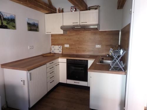 贝里斯泽尔Amsel Haus的小厨房配有白色橱柜和水槽