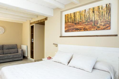 圣保Habitacions Plaça Major的卧室配有白色的床和沙发