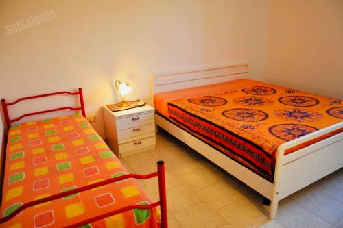 丽都玛里尼Casa Vacanza BERMUDA的一间卧室配有两张床和床头灯。