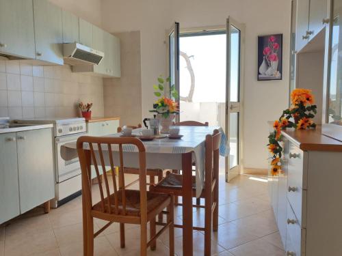 加利波利Appartamenti La Spiaggia的厨房配有桌椅
