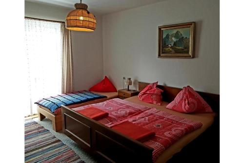 巴德加斯坦Pension Charlotte的一间卧室配有两张带红色枕头的床
