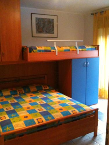 丰达切洛Taormina Mare Piscina Fondachello的一间卧室配有双层床和色彩缤纷的床罩