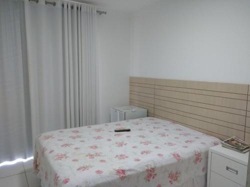伊塔齐米林Itacimirim - Quinta das Lagoas Residence的一间卧室配有一张带花卉床罩的床