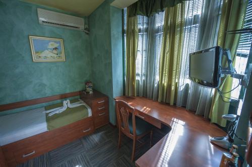 波德戈里察可贝尔酒店的小房间设有书桌和电视