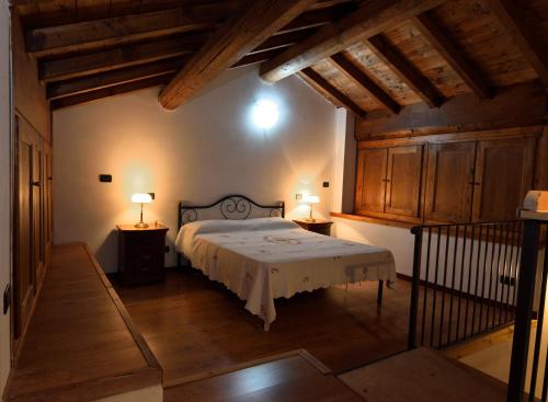 LermaB&B Il Borgo Fiorito的一间带一张大床的卧室,位于一个拥有木制天花板的房间