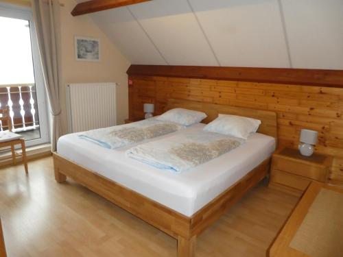布列登Huis Pimpernel的一间卧室配有一张大床和木制床头板