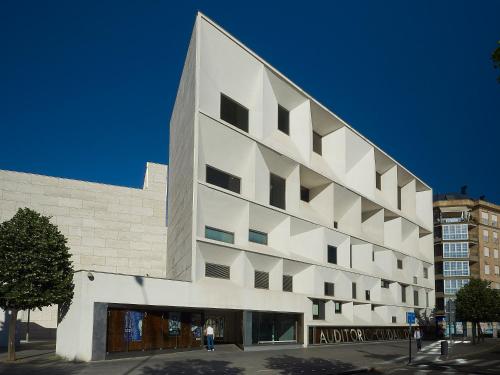 莱昂Entrevias Lodging - Apartamento con Garaje y WIFI的一座白色的大建筑,外面的人